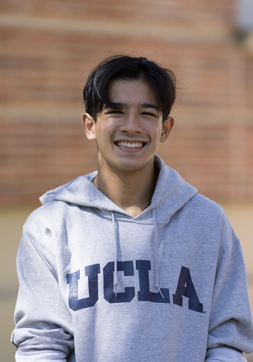 Nicholas Shinghal smiling at camera in a grey UCLA sweatshirt